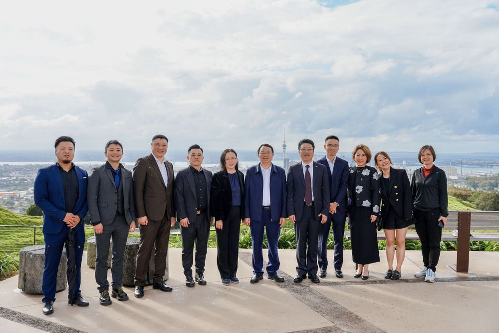 Group photo of a corporate business delegation outside a retail store, captured by an Auckland commercial photographer.