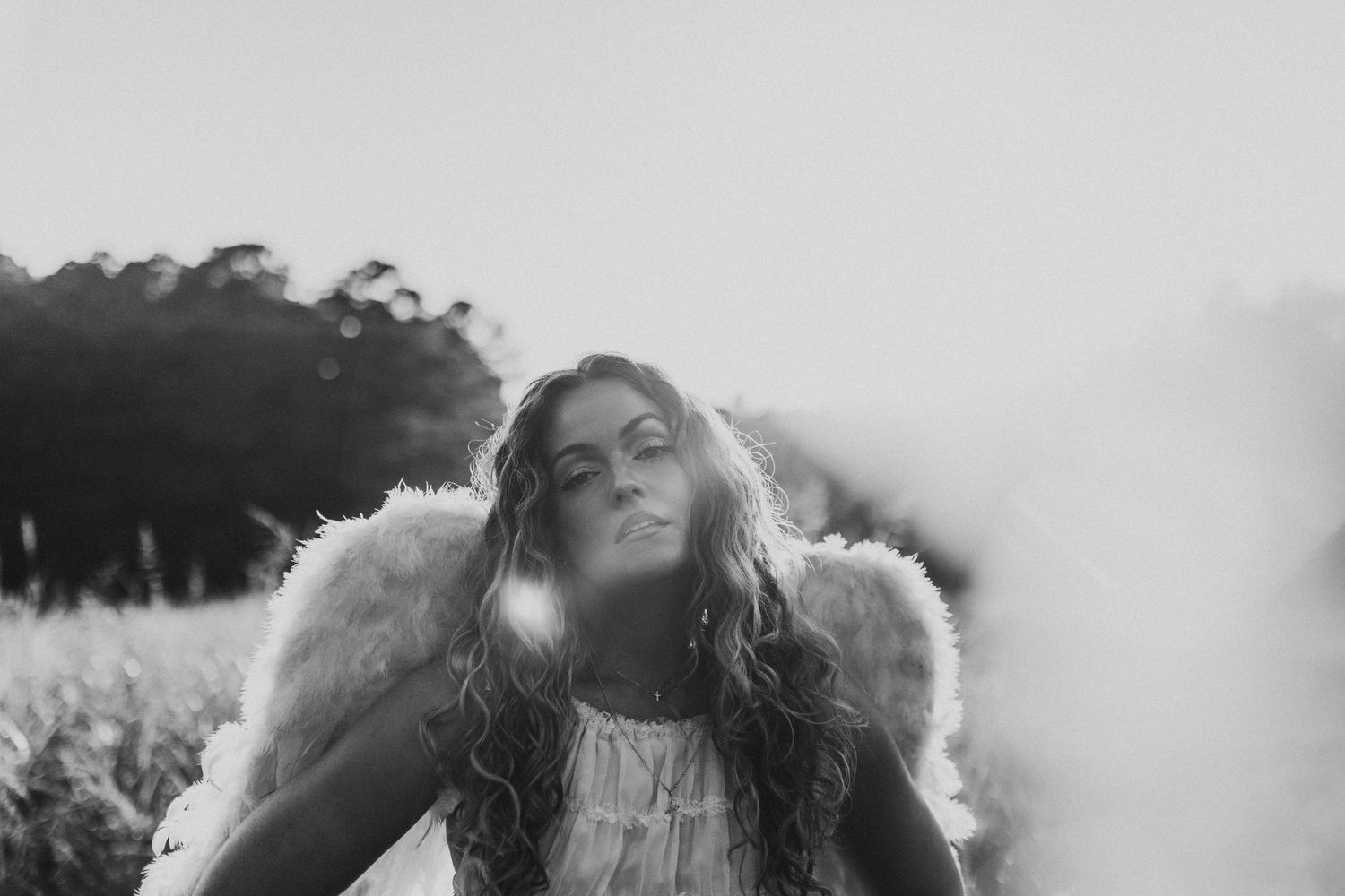 Senior black and white photo with wings in a field