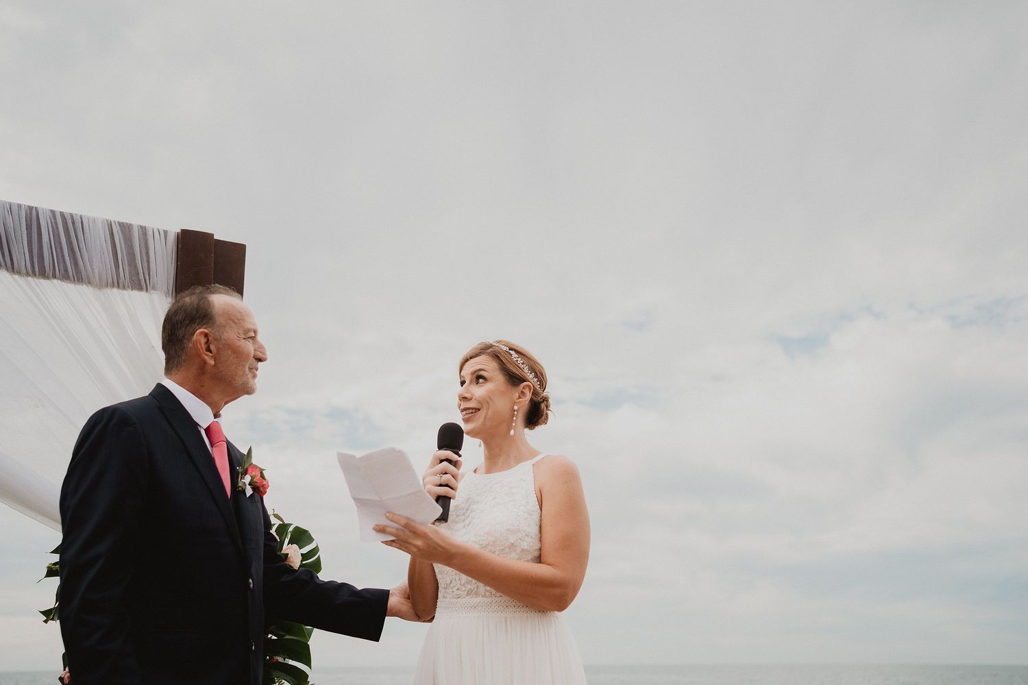 Novia leyendo sus votos durante una ceremonia de boda frente al mar en Mazatlán
