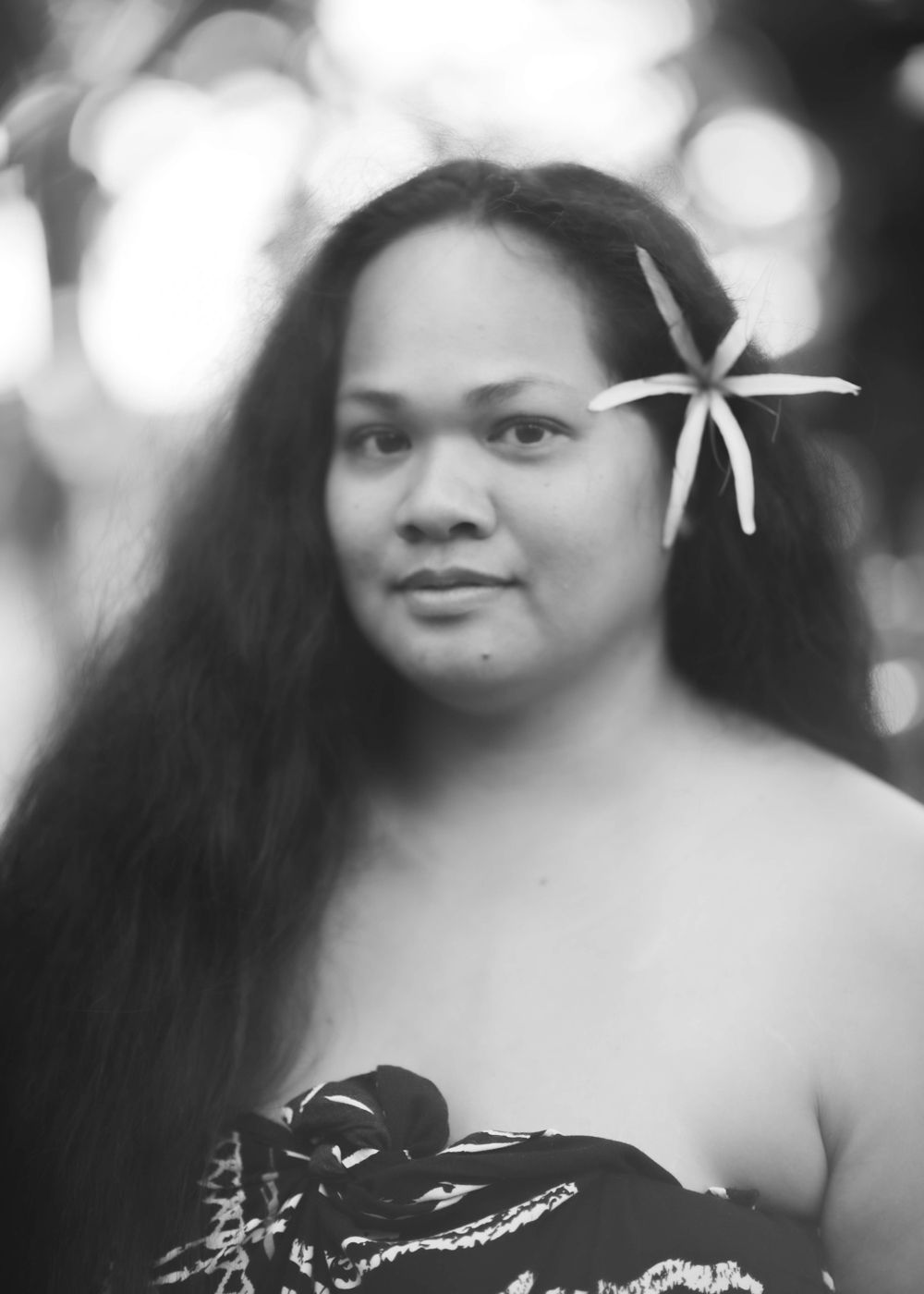 Black and white portrait with white flower hair accessory.