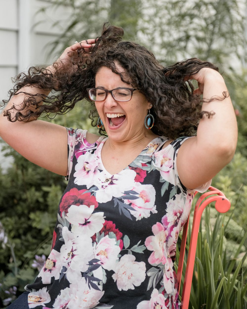 Joyful portrait in floral dress with natural curly hair.