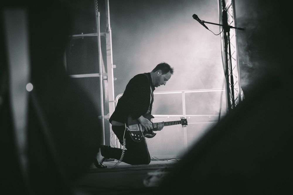 A dramatic black and white photo sequence shows a person playing guitar near a window with moody lighting.