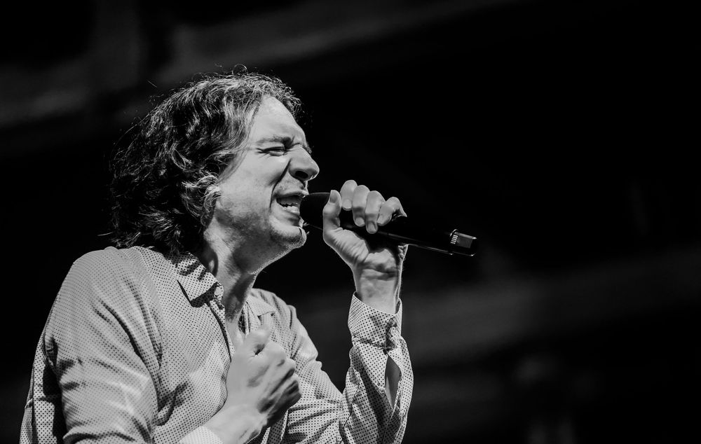 Black and white concert photography captures energetic performance with dramatic lighting.