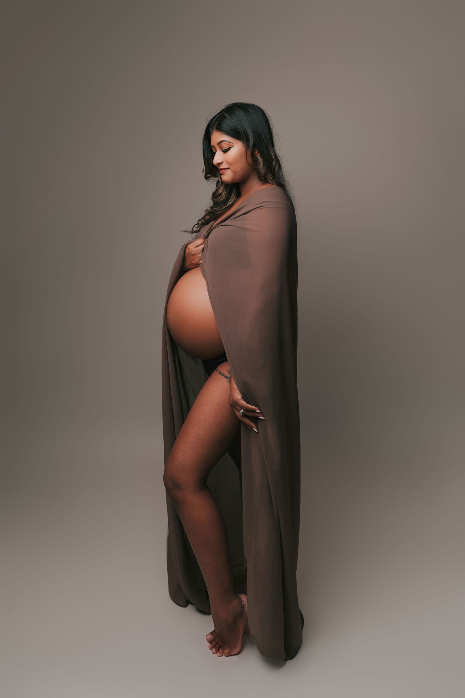 Artistic maternity portraits in brown tones showing pregnancy silhouette.
