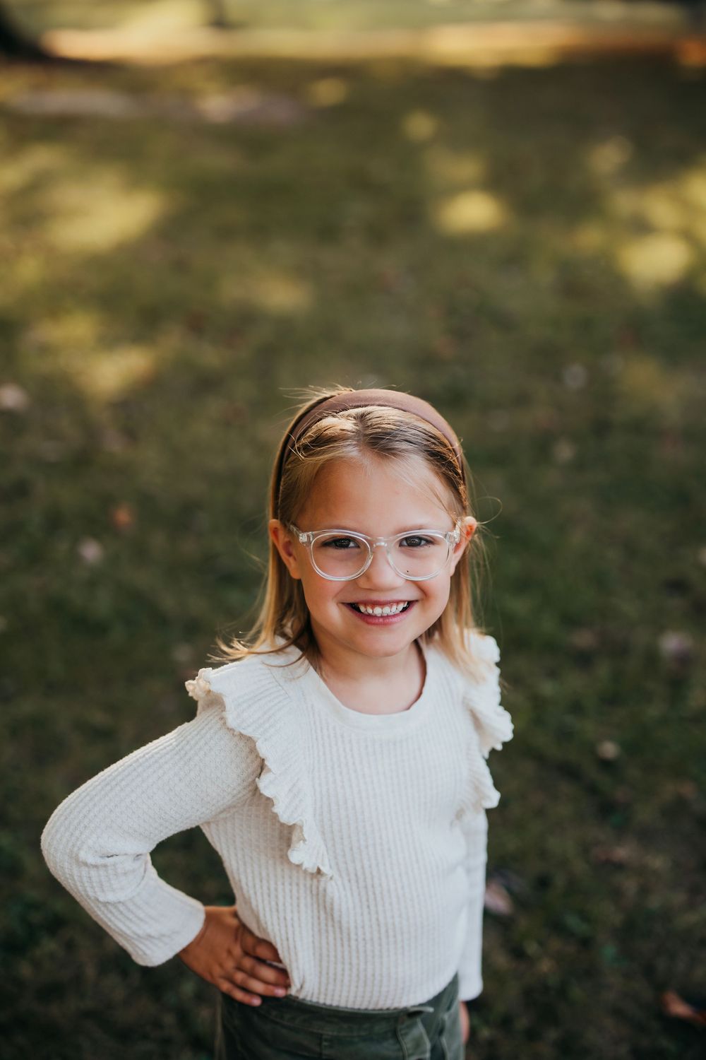 Close-up portrait series showing joyful expressions and a white knit sweater against a natural outdoor background.