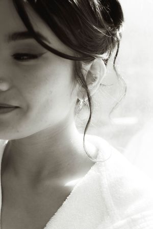 Artistic black and white close-up profile shot showing elegant bridal hairstyle and jewelry.