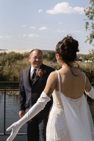 Newlyweds share a joyful interaction on an outdoor deck with water views.