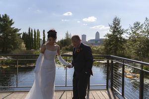 A sunny wedding ceremony on a wooden deck with water and city views in the background.