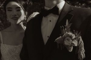 An artistic black and white wedding portrait with elegant formal attire.