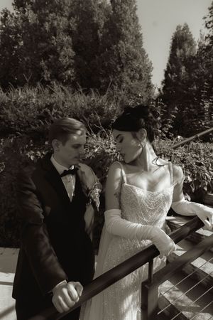 A black and white series of wedding portraits showing tender moments by a railing.