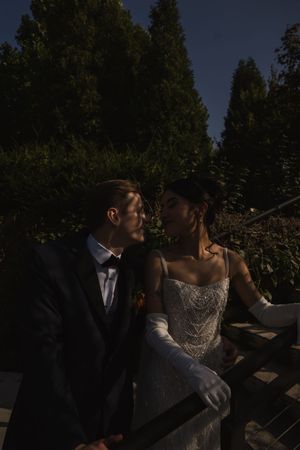 A romantic nighttime portrait session in a garden setting with dramatic lighting.