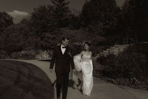 A dramatic evening wedding portrait with trees silhouetted against the darkening sky.
