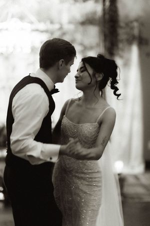 Black and white photos capture an intimate dance between newlyweds in formal attire.