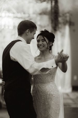 Black and white photos showing a joyful dance between newlyweds in an elegant setting.