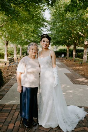 Wedding photo on brick pathway with white dress and natural garden backdrop.