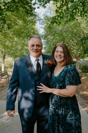 Couple in formal attire shares a loving moment during outdoor wedding photography.