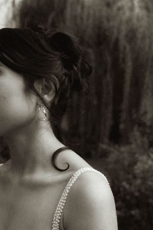 Artistic black and white detail shot of a beaded wedding dress strap and shoulder.