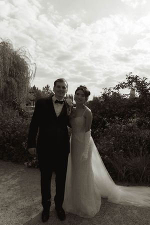 A wedding couple walking together on a garden path in black and white.