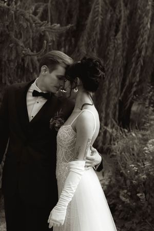 An intimate black and white portrait of newlyweds sharing a tender moment.