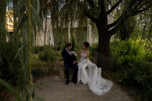 Couple shares tender moments during outdoor wedding photography session in natural garden setting.