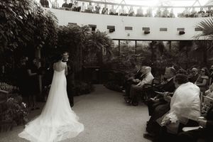 A panoramic view of an outdoor wedding ceremony with string lights overhead.
