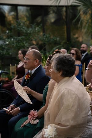 Wedding guests seated in formal attire watching an emotional ceremony.