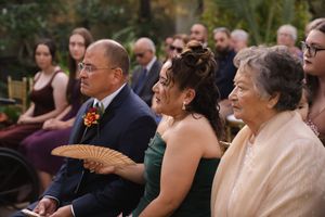 Guests watching intently during a garden wedding ceremony.