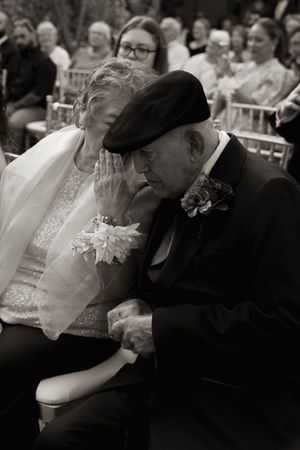 Wedding guests show emotional reactions during a touching ceremony moment.