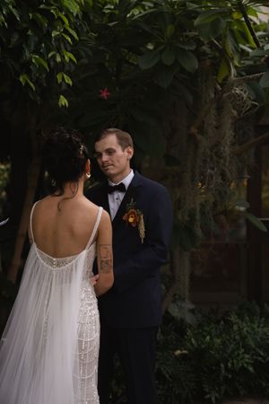 Couple shares an intimate moment in a lush garden setting during their wedding.