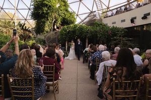 Wide angle view of wedding guests seated under geometric dome structure.