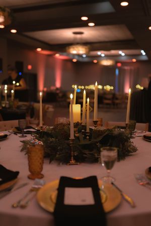 Intimate wedding reception table with candlelit centerpiece and elegant place settings.