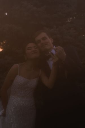 Intimate dancing moment captured between newlyweds in low evening light.