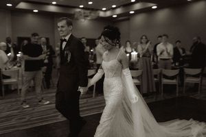 A black and white photo of a couple's first dance at their wedding reception.
