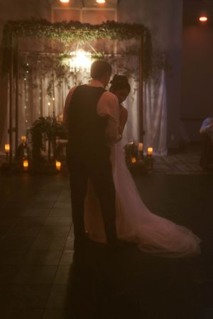 Couples dancing in a dimly lit ballroom during an evening wedding reception.