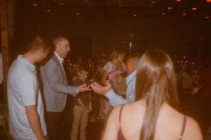 People dancing and socializing at a dimly lit evening party.