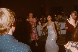 Crowded dance floor with party guests enjoying music at a nighttime celebration.