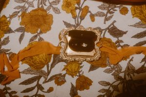 Vintage floral wallpaper pattern featuring golden flowers and leaves on a cream background.