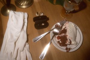 Elegant table settings with white linens and formal place settings at a wedding reception.