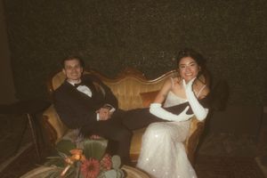 A couple relaxing on vintage furniture at their wedding reception.