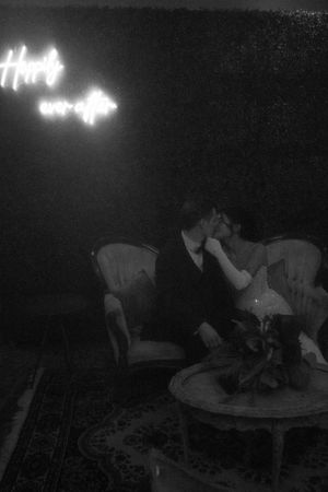 Silhouetted couple poses on furniture with glowing text visible in the dark background.