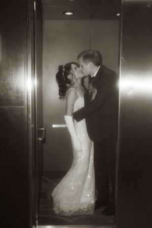 A romantic moment captured in an elevator with sparkling dress details.