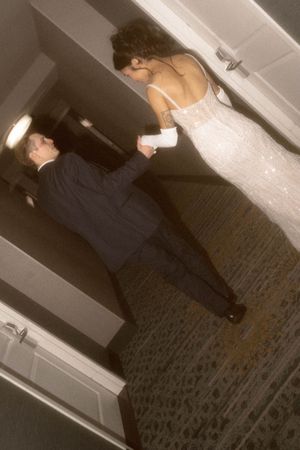 Couple walking through a dimly lit hotel corridor.