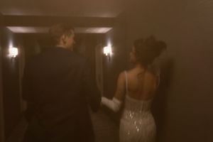 Wedding party members walking through a dimly lit corridor.