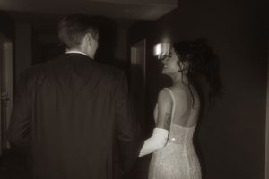 Elegant wedding dress detail shown in dramatic lighting at an evening event.