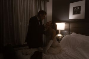 Interior of a hotel room with soft lighting and curtained windows.