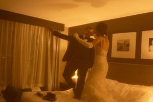 A sepia-toned photo captures a couple dancing together in a hotel room.