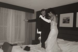 A couple dances together in an intimate moment in their hotel room.