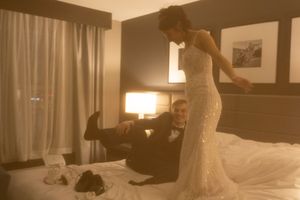 A couple shares an intimate dance moment in a hotel room setting.