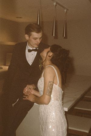 Romantic dance sequence between a couple in formal attire.