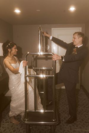 Couple dancing with a metal serving cart at a formal event.